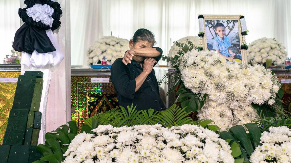 Flowers and toys at funeral for Thai school bus fire victims